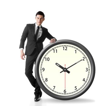 Asian businessman standing with a clock, concept of time manage or plan.