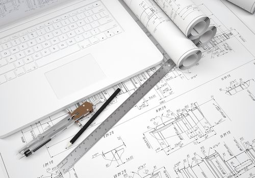 Scrolls engineering drawings and laptop. Desk Engineer
