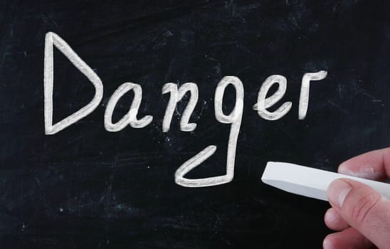 danger handwritten with chalk on a blackboard