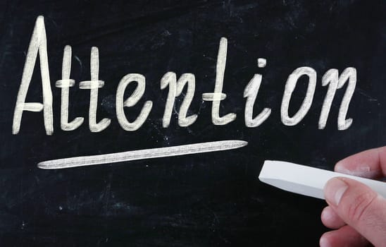 attention handwritten with chalk on a blackboard