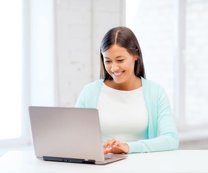 education concept - smiling international student girl with laptop at school