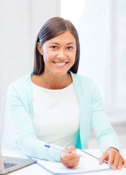 business, education and technology concept - asian businesswoman or student with laptop and documents in office