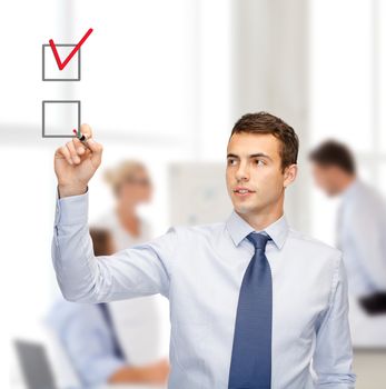 business and office concept - attractive buisnessman or teacher with marker drawning red checkmark into checkbox