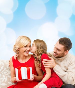 family, christmas, x-mas, winter, happiness and people concept - adorable child kisses her mother and gives present