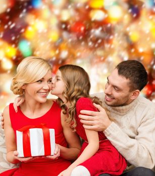 family, christmas, x-mas, winter, happiness and people concept - adorable child kisses her mother and gives present