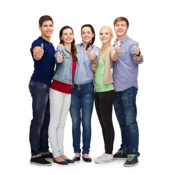 education and people concept - group of smiling students standing and showing thumbs up