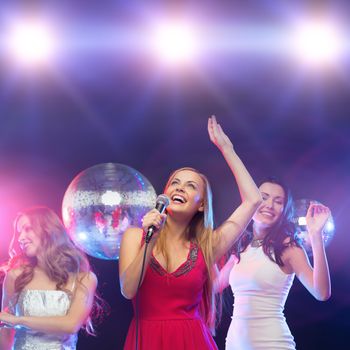 party, new year, celebration, friends, bachelorette party, birthday concept - three women in evening dresses dancing and singing karaoke