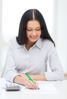 business, education and tax concept - smiling businesswoman or student working with calculator