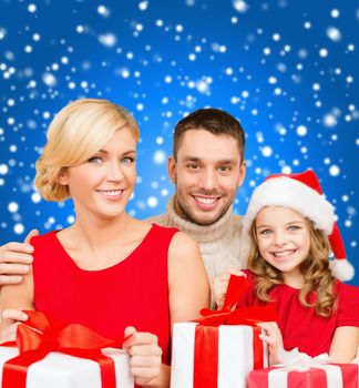 family, christmas, x-mas, winter, happiness and people concept - smiling family in santa helper hats with many gift boxes