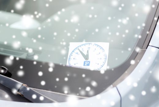 transportation and vehicle concept - parking clock on car dashboard under windscreen