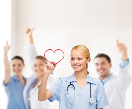 healthcare, medical and technology - young doctor or nurse drawing red heart