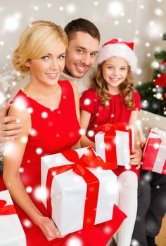 family, christmas, x-mas, winter, happiness and people concept - smiling family in santa helper hats with many gift boxes