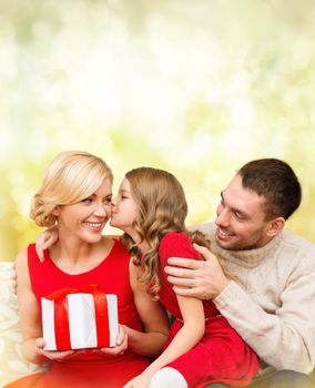 family, christmas, x-mas, winter, happiness and people concept - adorable child kisses her mother and gives present