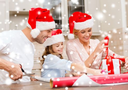 christmas, x-mas, winter,family, happiness and people concept - smiling family in santa helper hats with gift box