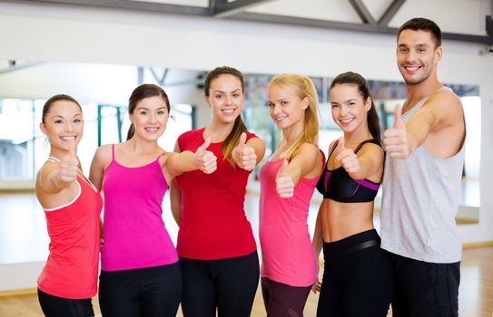 fitness, sport, training, gym and lifestyle concept - group of happy people in the gym showing thumbs up