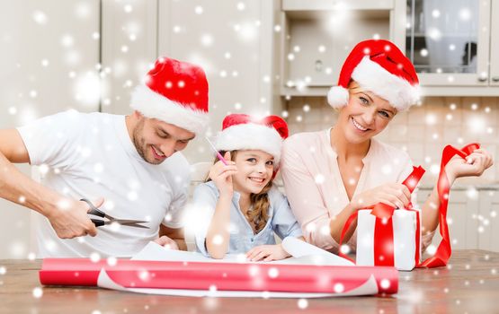 christmas, x-mas, winter,family, happiness and people concept - smiling family in santa helper hats with gift box