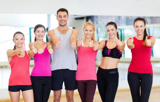 fitness, sport, training, gym and lifestyle concept - group of happy people in the gym showing thumbs up