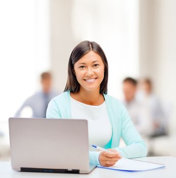 business, education and technology concept - asian businesswoman or student with laptop and documents in office