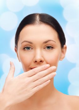 spa, health and beauty concept - beautiful woman covering her mouth