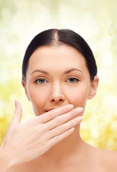 spa, health and beauty concept - beautiful woman covering her mouth