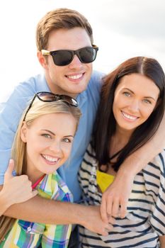 summer, holidays, vacation and happiness concept - group of friends having fun on the beach