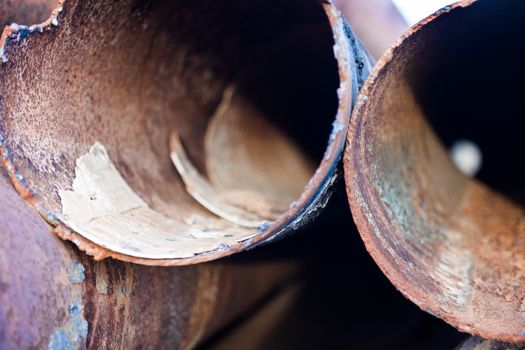 Closeup of the rusty metal pipes orifices.