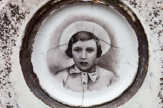 Portrait of the young girl on the old gravestone.