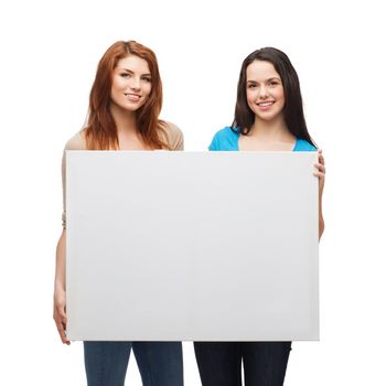 advertisement, sale and people concept - smiling young girls with blank white board