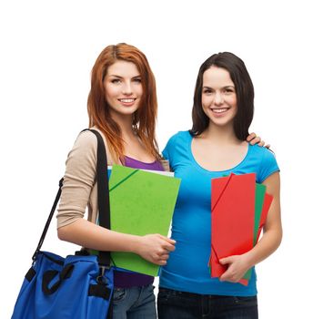 education and people concept - two smiling students with bag and folders standing