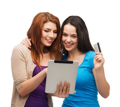 online shopping and technology concept - two smiling teenagers with tablet pc computer and credit card