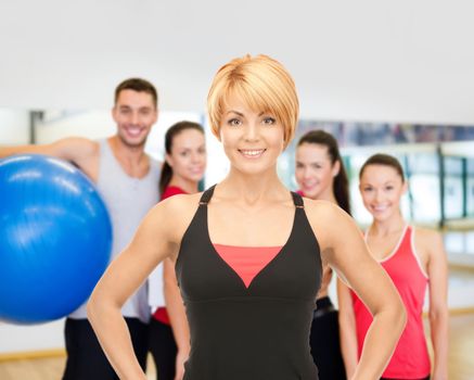 fitness, sport, training, gym and lifestyle concept - group of smiling people with trainer exercising in the gym