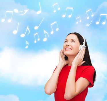 music and technology concept - smiling young woman with headphones