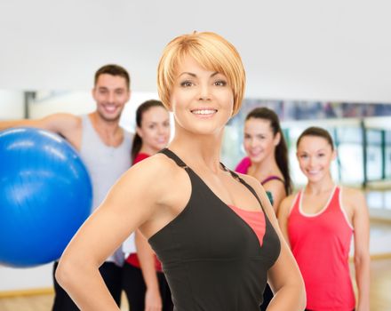 fitness, sport, training, gym and lifestyle concept - group of smiling people with trainer exercising in the gym