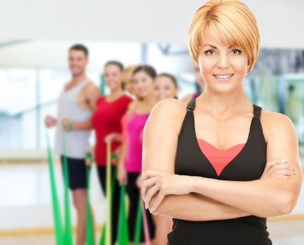 fitness, sport, training, gym and lifestyle concept - group of smiling people with trainer exercising in the gym