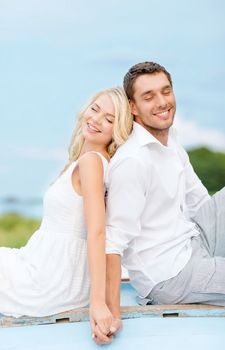 summer holidays and dating concept - smiling couple at sea side