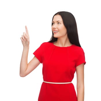 advertisement concept - attractive young woman in red dress pointing her finger up
