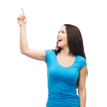 advertisement concept - attractive teenager in casual clothes pointing her finger up