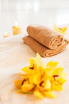 spa, health and beauty concept - closeup of towels, flowers and candles