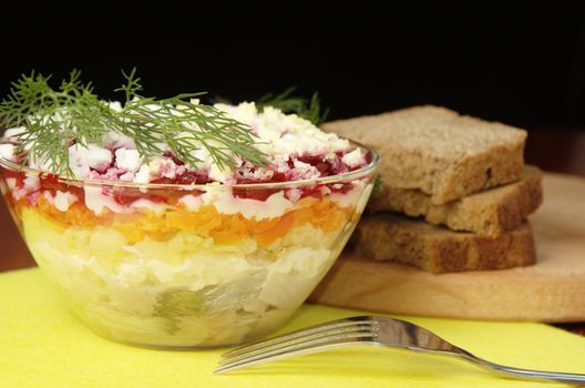 Russian traditional herring salad in glass bowl