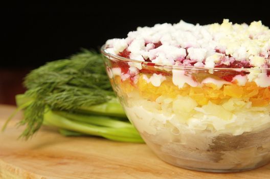 Russian traditional herring salad in glass bowl