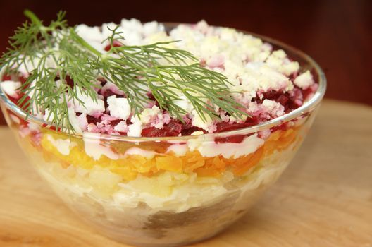 Russian traditional herring salad in glass bowl