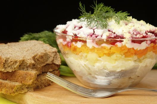 Russian traditional herring salad in glass bowl