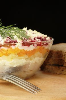 Russian traditional herring salad in glass bowl