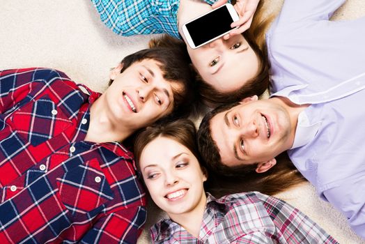 four young men lie together, young attractive woman pressed her lips to the phone