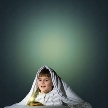 image of a boy under the covers with a flashlight