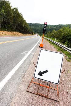 temporary Red Street Light Post and Blank Board with Arrow on a Construction Site