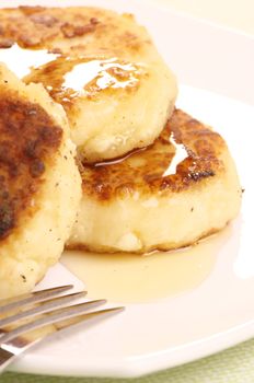 Delicious homemade cheese pancakes with honey closeup