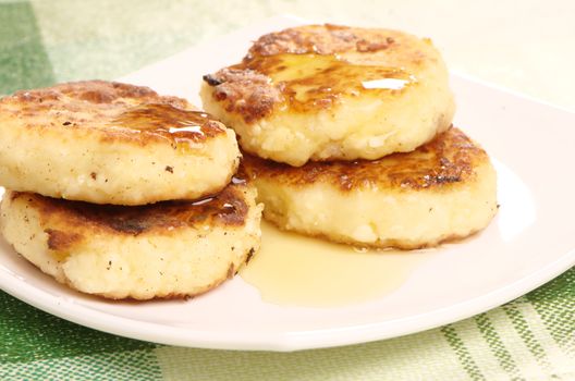 Delicious homemade cheese pancakes with honey closeup