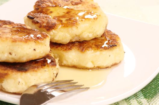 Delicious homemade cheese pancakes with honey closeup