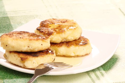 Delicious homemade cheese pancakes with honey closeup